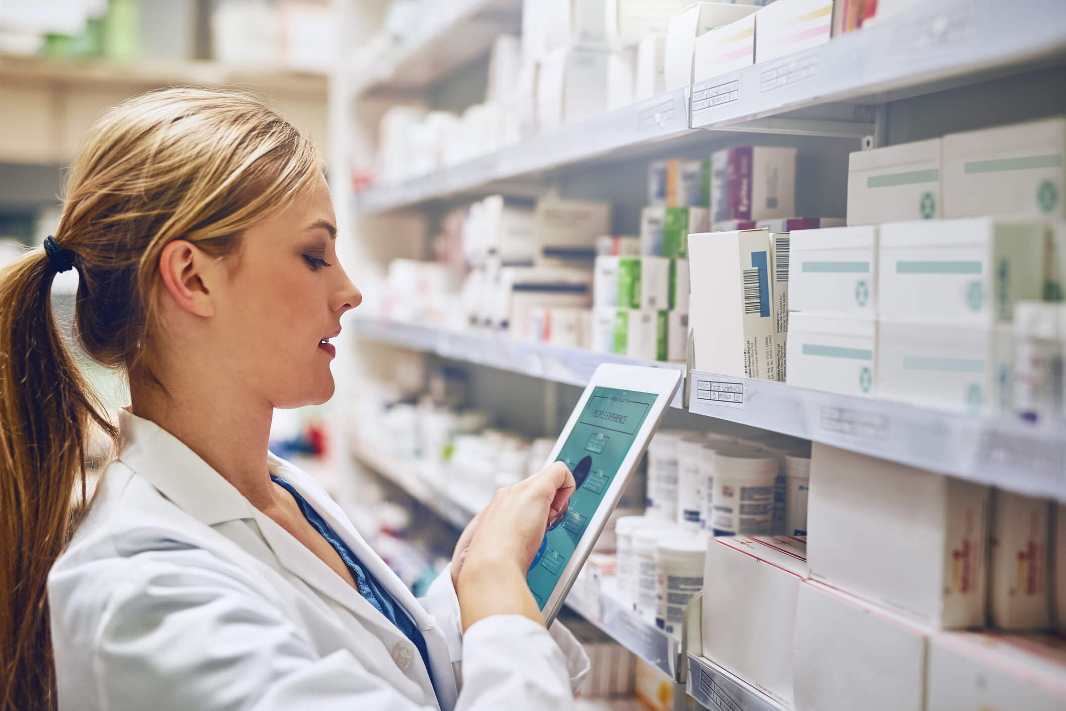 Pharmacy worker checking drug inventory on ipad